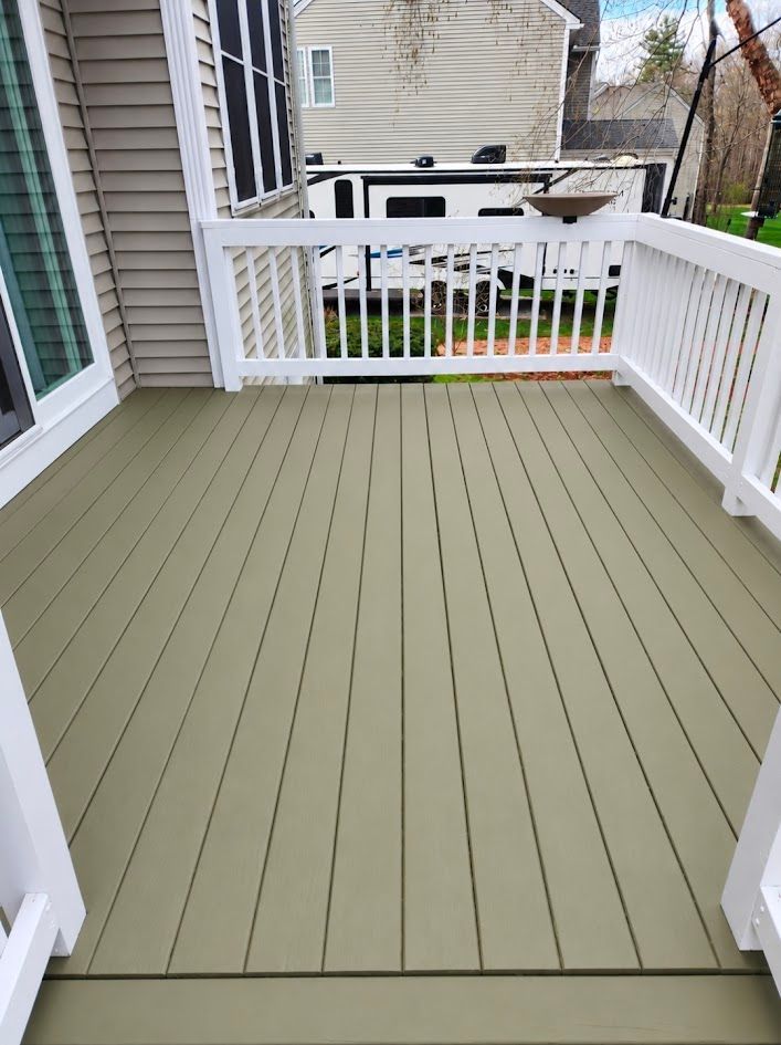 White-railed porch with green floorboards, overlooking a backyard and neighboring houses.
