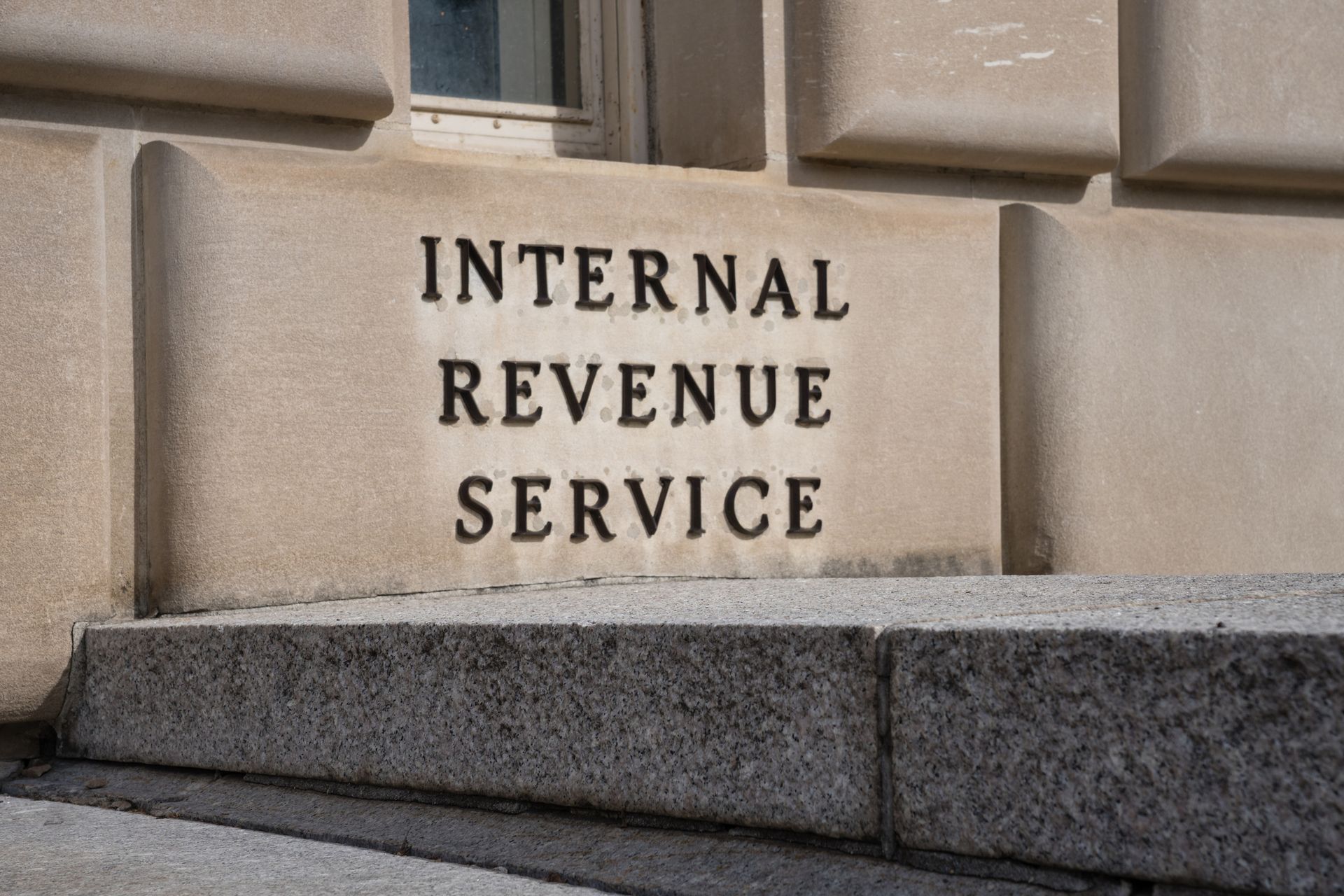 A sign for the internal revenue service is on the side of a building.