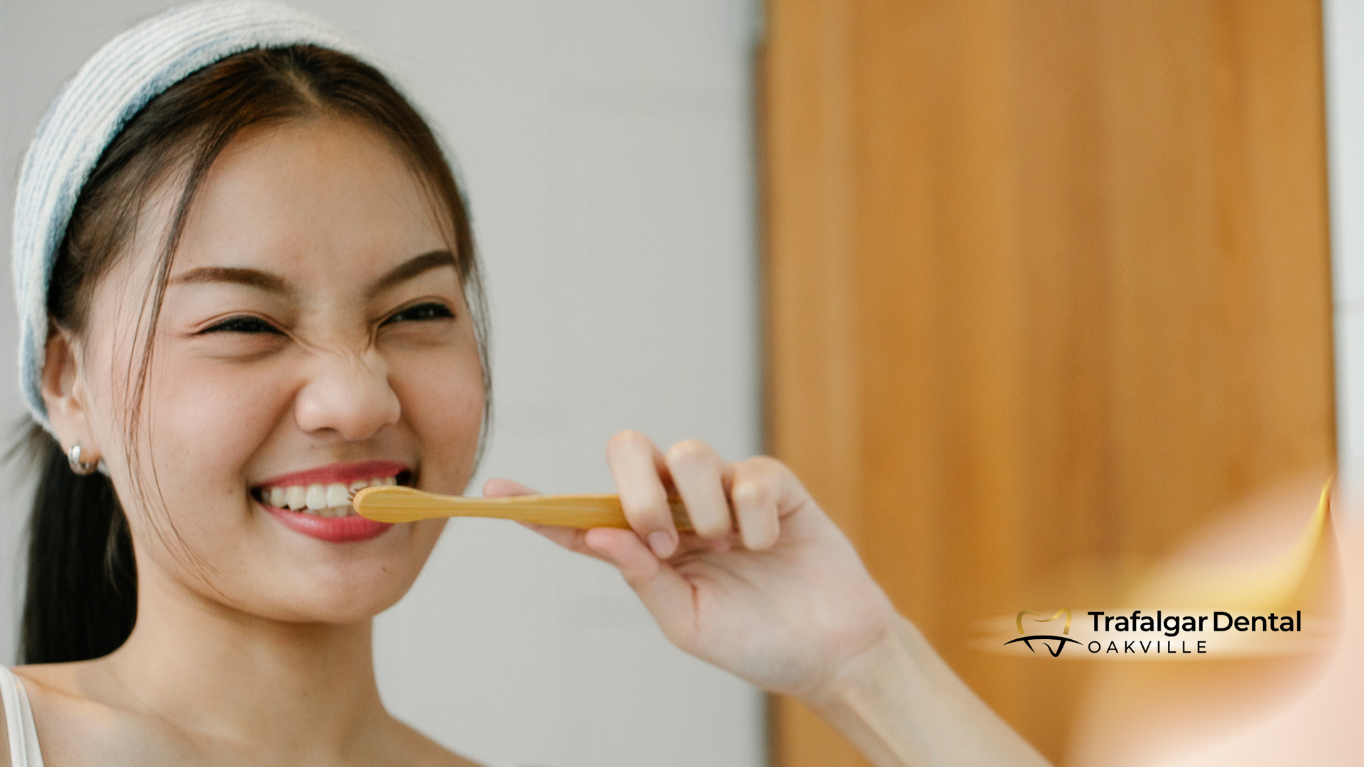 A woman is brushing her teeth in front of a mirror.