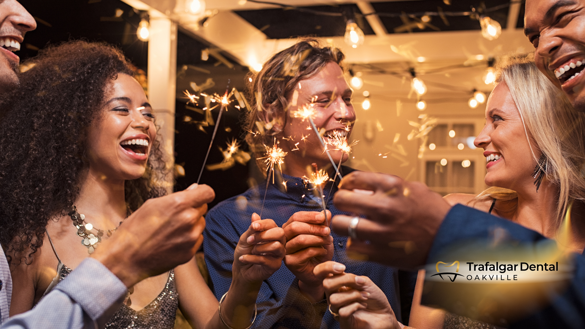 A group of people are holding sparklers at a party.