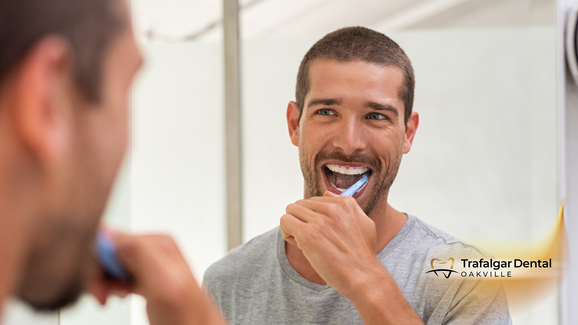 A man is brushing his teeth in front of a mirror.