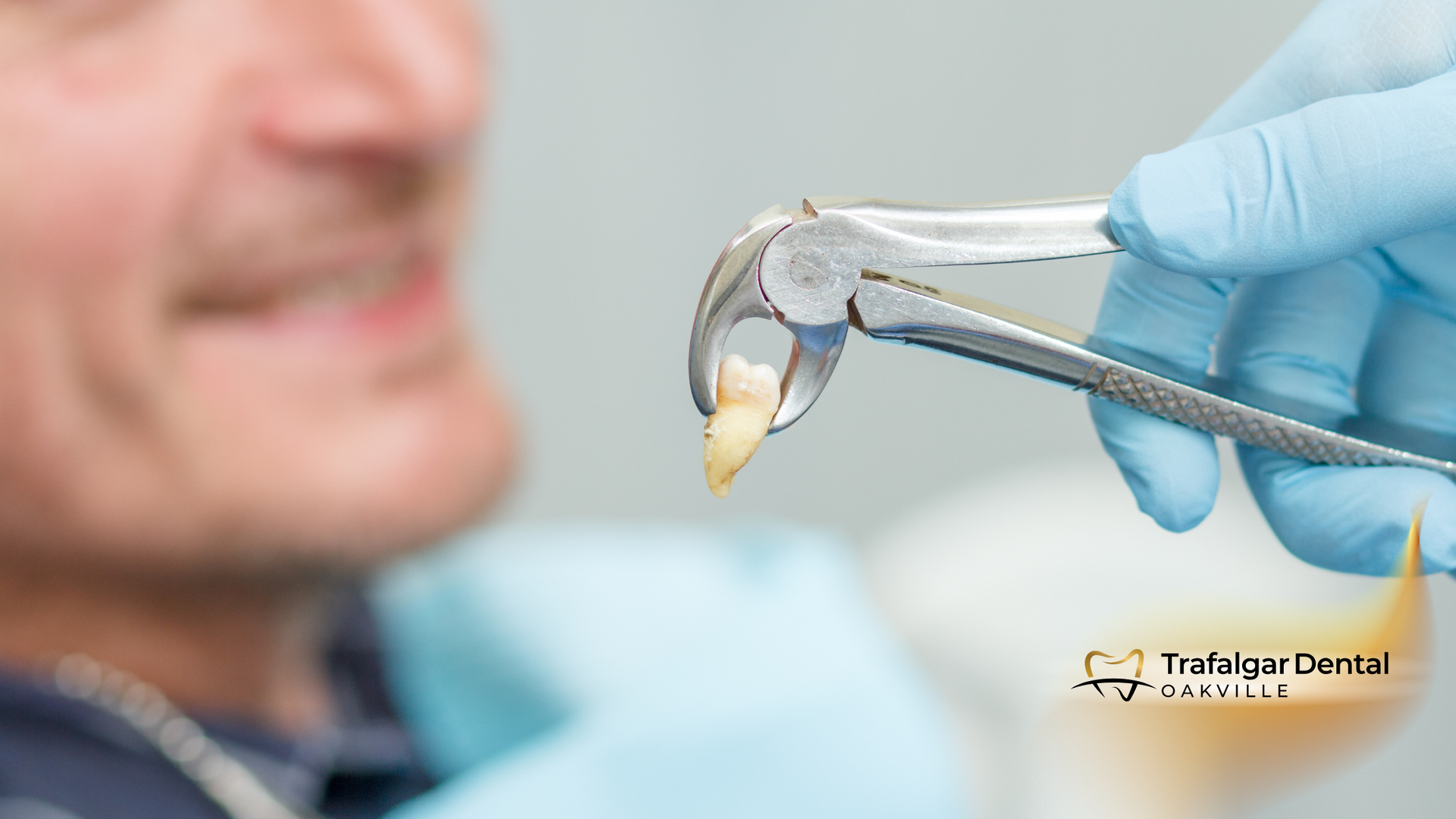A dentist is removing a patient 's tooth with a pair of pliers.