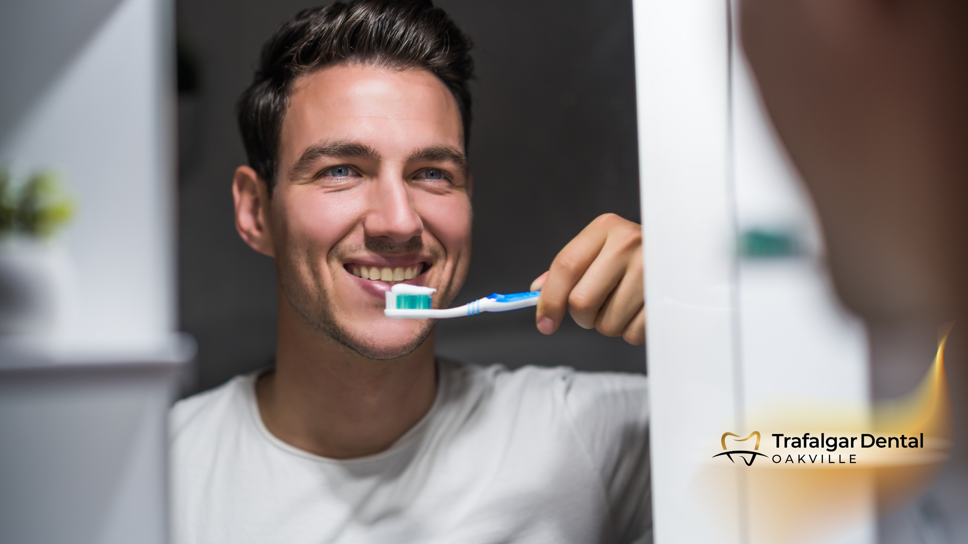 A man is brushing his teeth in front of a mirror.