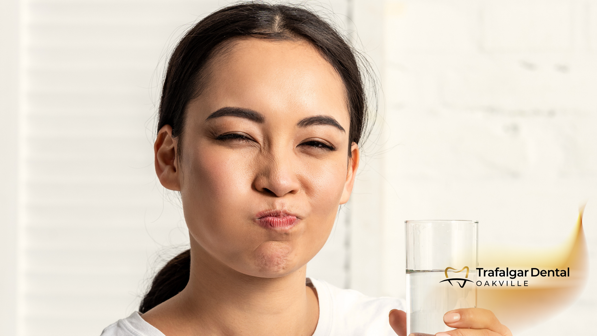 A woman is holding a glass of milk in her hand.