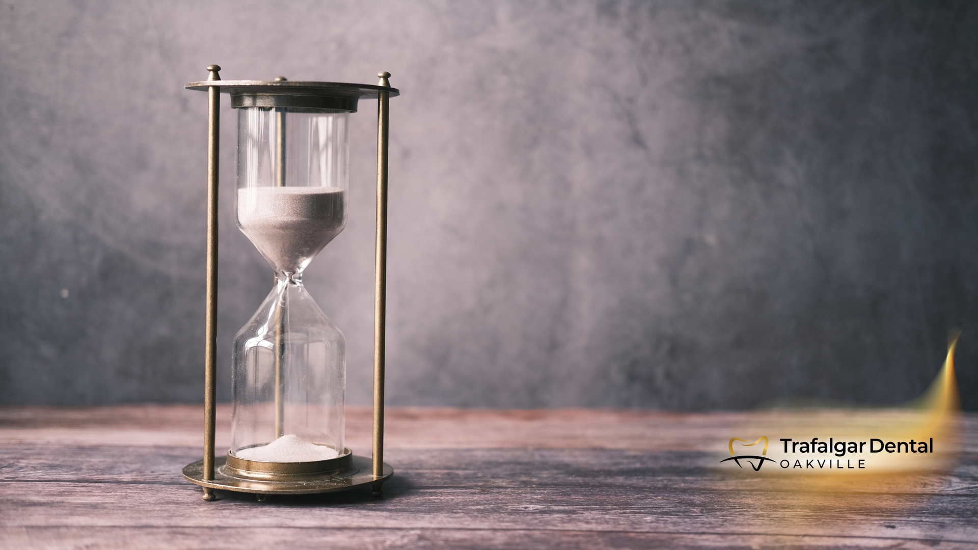A hourglass is sitting on a wooden table.