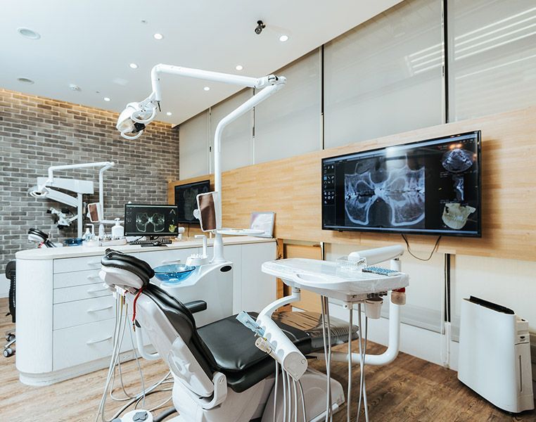 A person is using a calculator next to a tooth model.