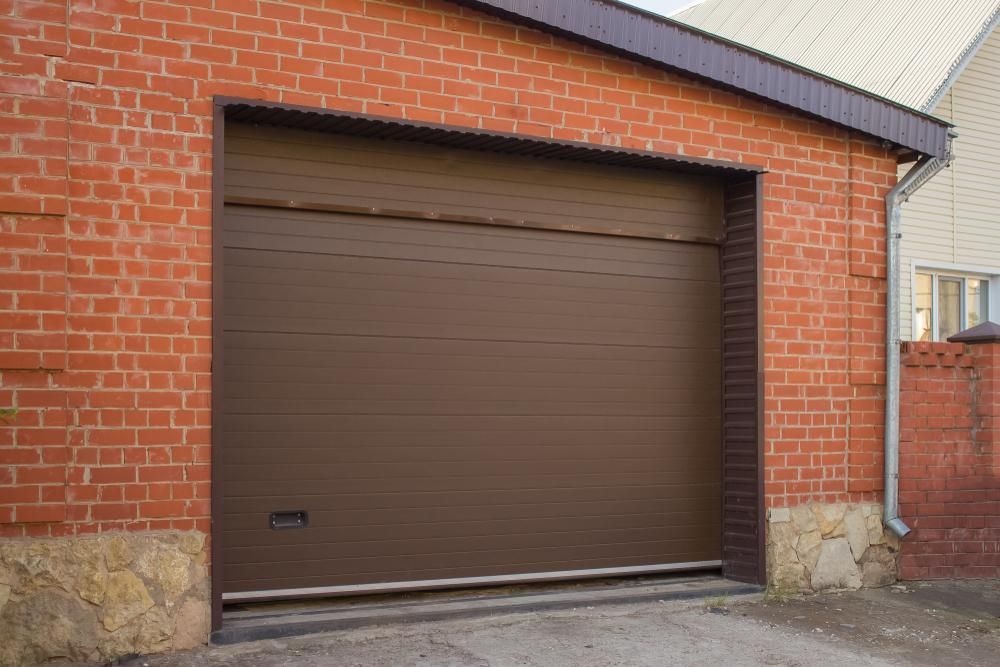 a Brown Garage Door is Sitting in Front of a Brick Building — Armstrong Locksmiths Ballarat In Bacchus Marsh, VIC