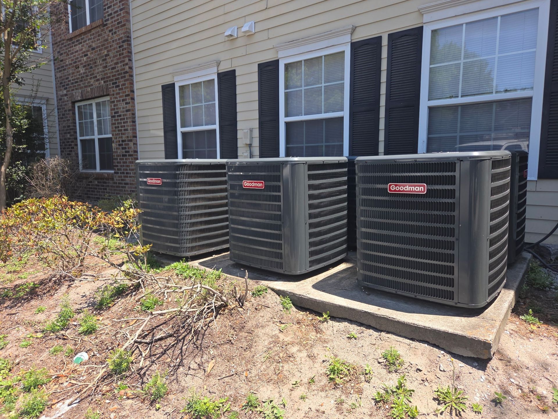HVAC technician performing air conditioning unit maintenance with pressure gauges outdoors.
