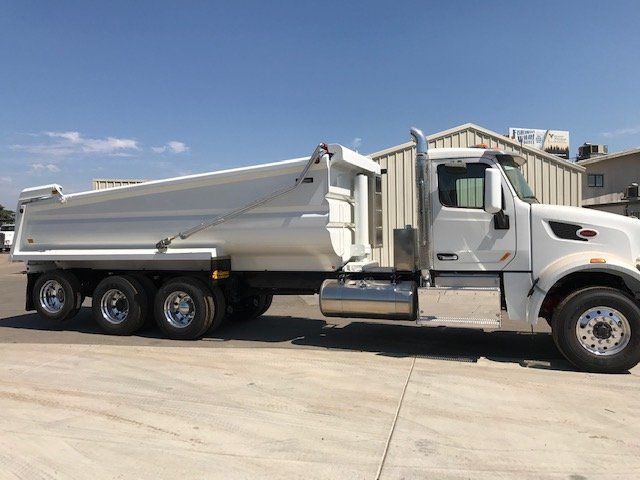 A white dump truck is parked in a parking lot.