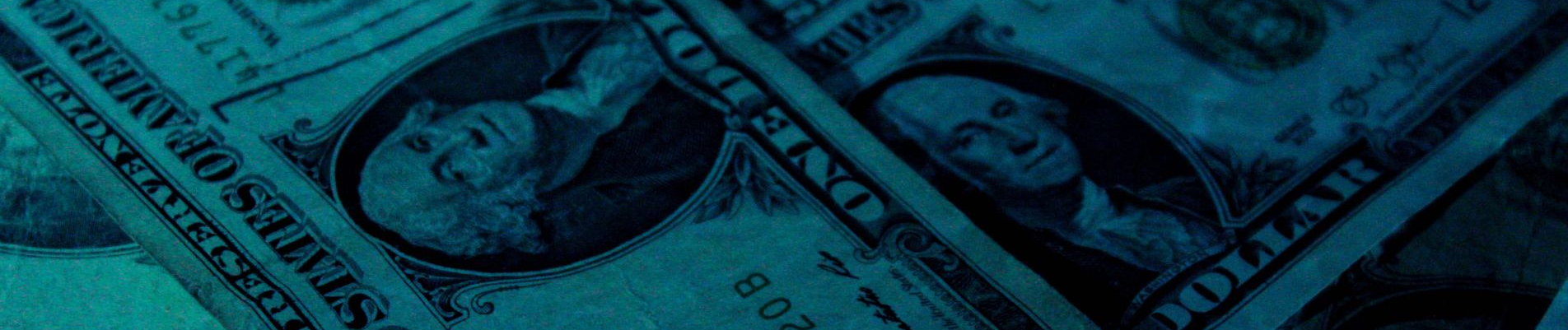 A close up of a pile of dollar bills on a blue background.