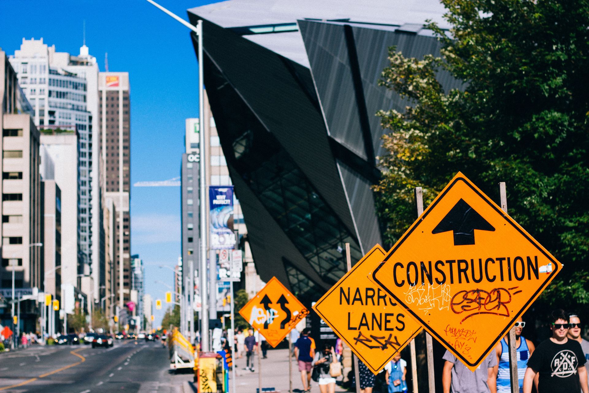 A construction sign is on the side of a city street