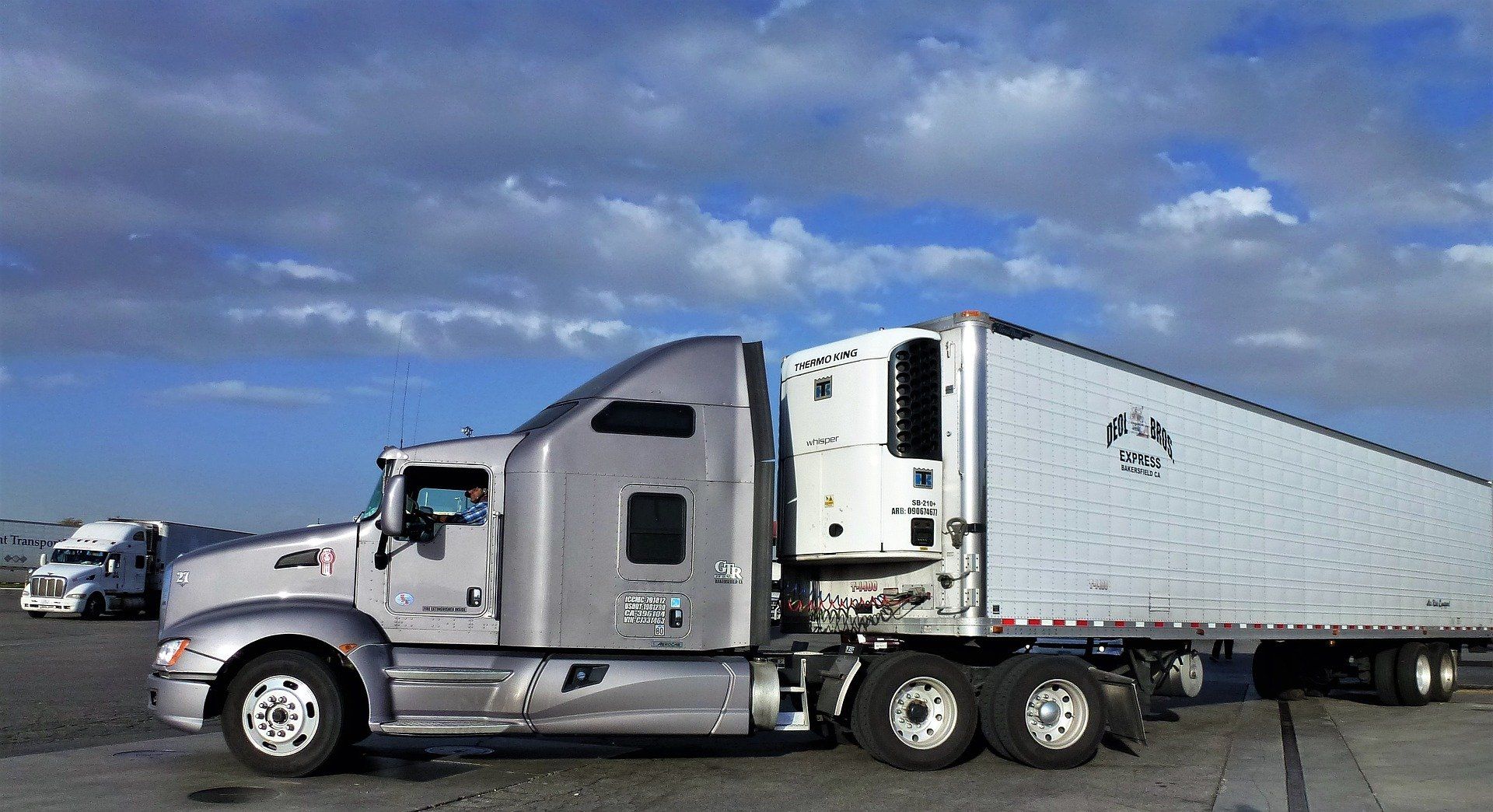 A semi truck with a trailer attached to it is parked on the side of the road.