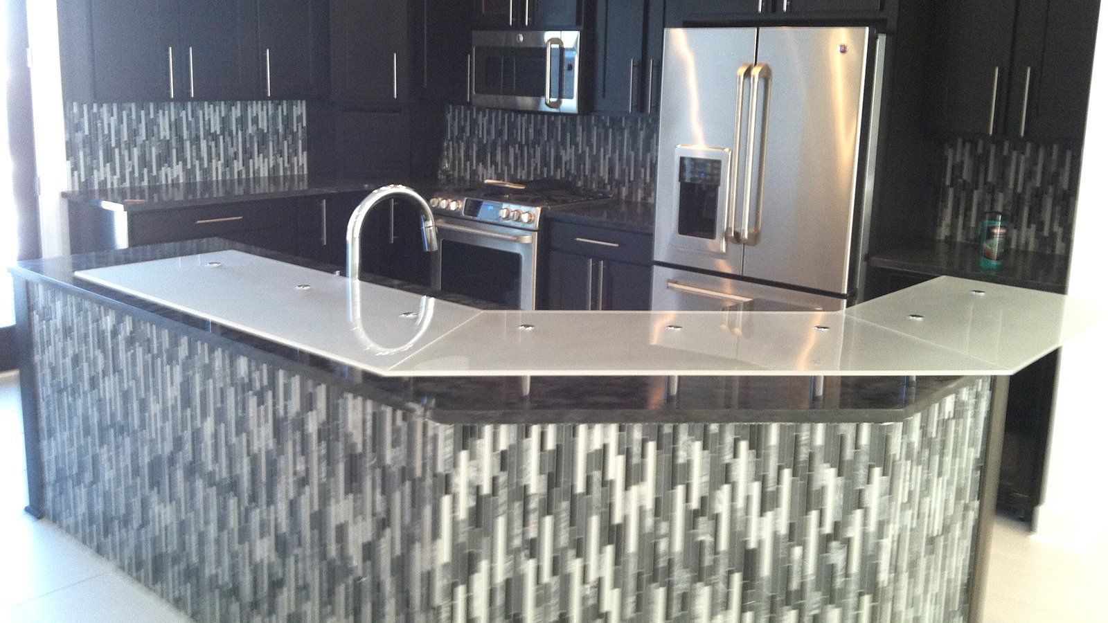 A kitchen with black cabinets and stainless steel appliances
