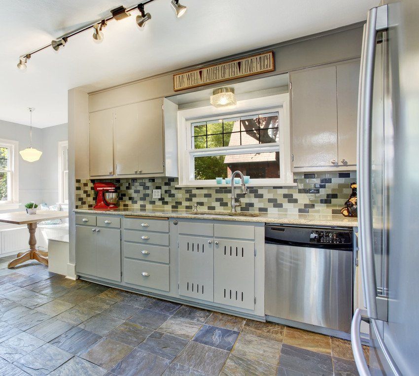 A kitchen with gray cabinets and stainless steel appliances