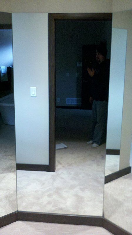 A man is standing in front of a mirror in a bathroom