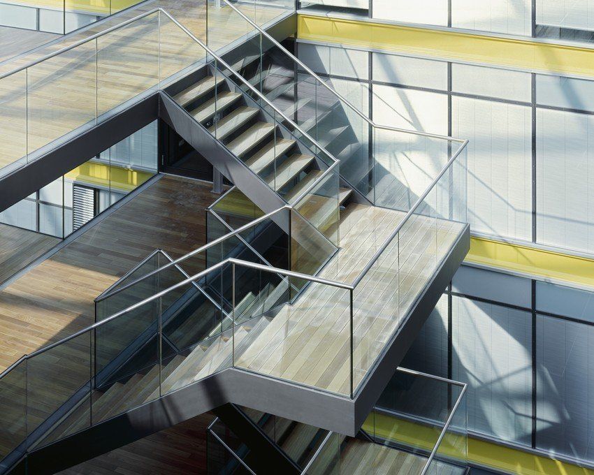 A staircase in a building with a glass railing