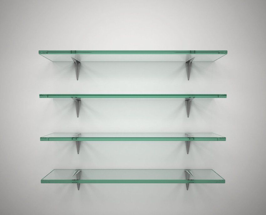 Three empty glass shelves on a white wall.