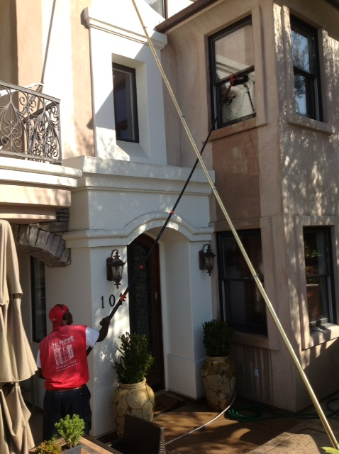 A Man Cleaning The Windows Of A House With The Number 10 On It