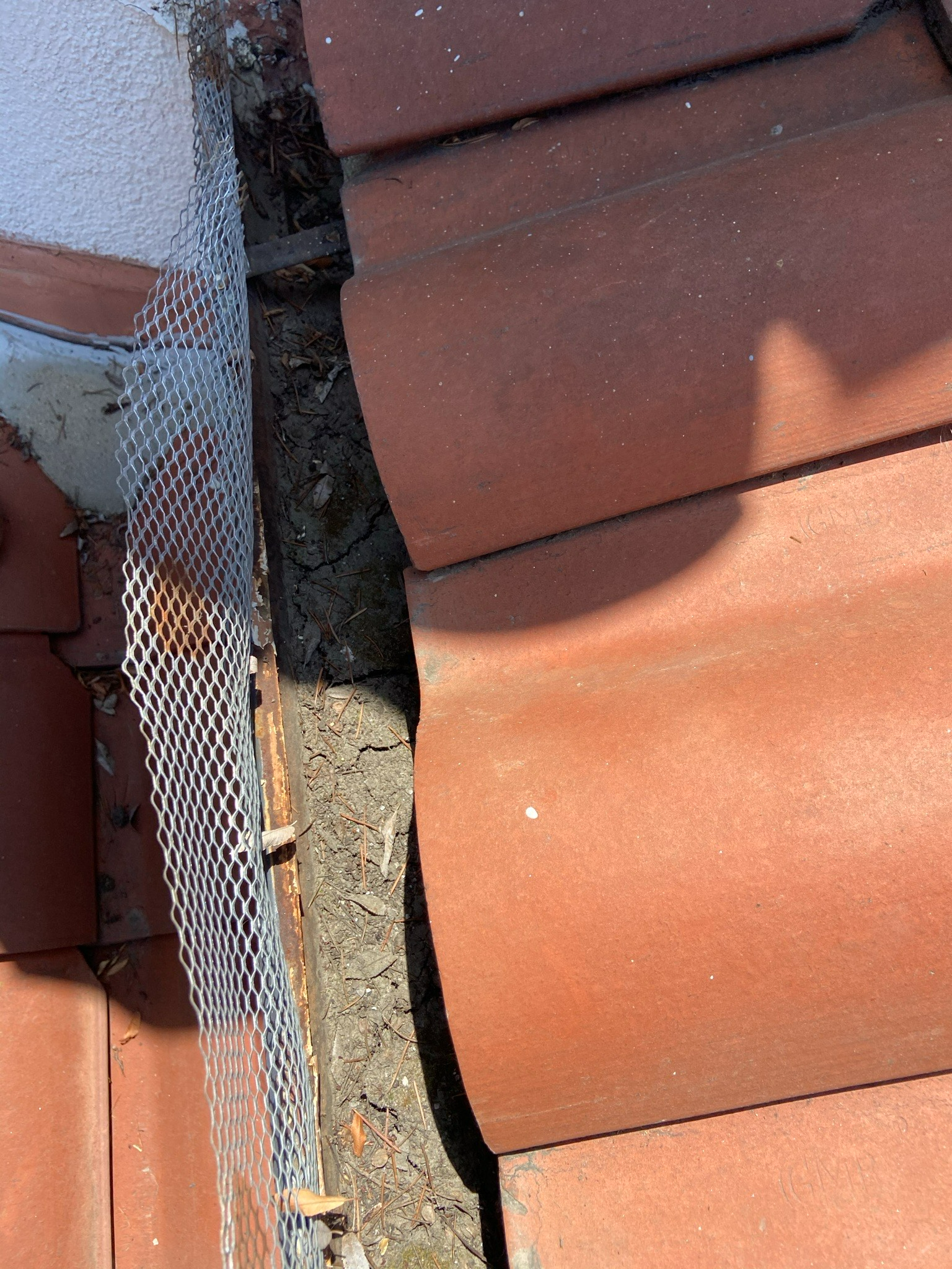 A Close Up Of A Gutter On A Tiled Roof