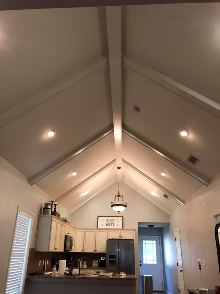 Kitchen with vaulted white ceiling, recessed lights, and a pendant light above the kitchen island.