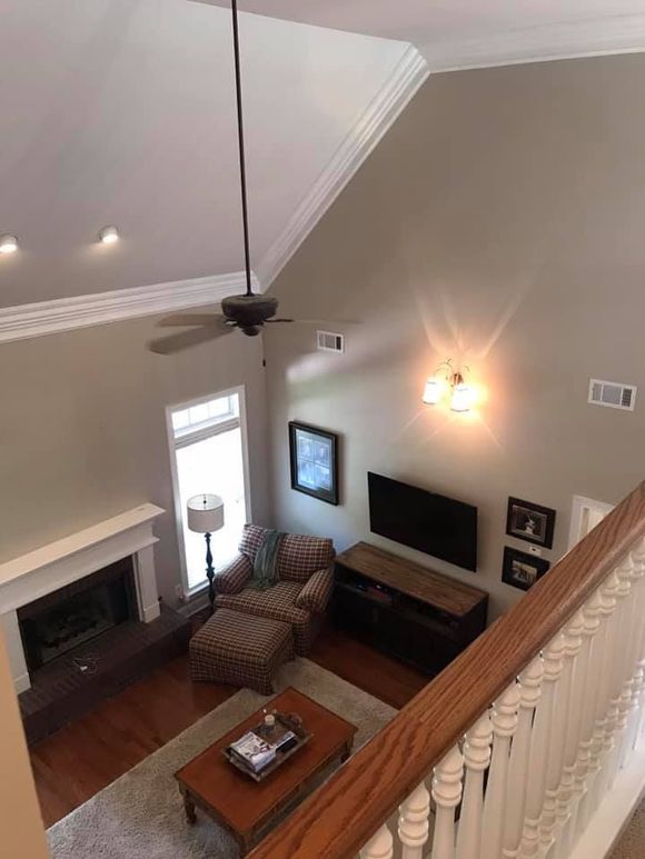 Living room from above: neutral walls, fireplace, TV, seating area, hardwood floors.
