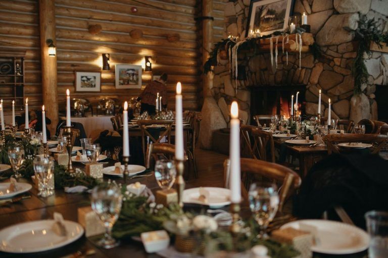 A table set for a wedding reception with candles on it.