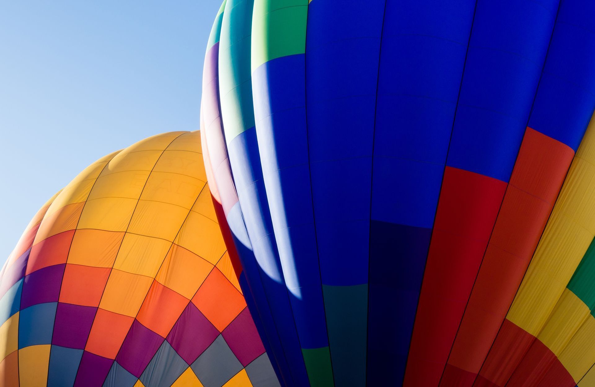 Three colorful hot air balloons are flying in the sky
