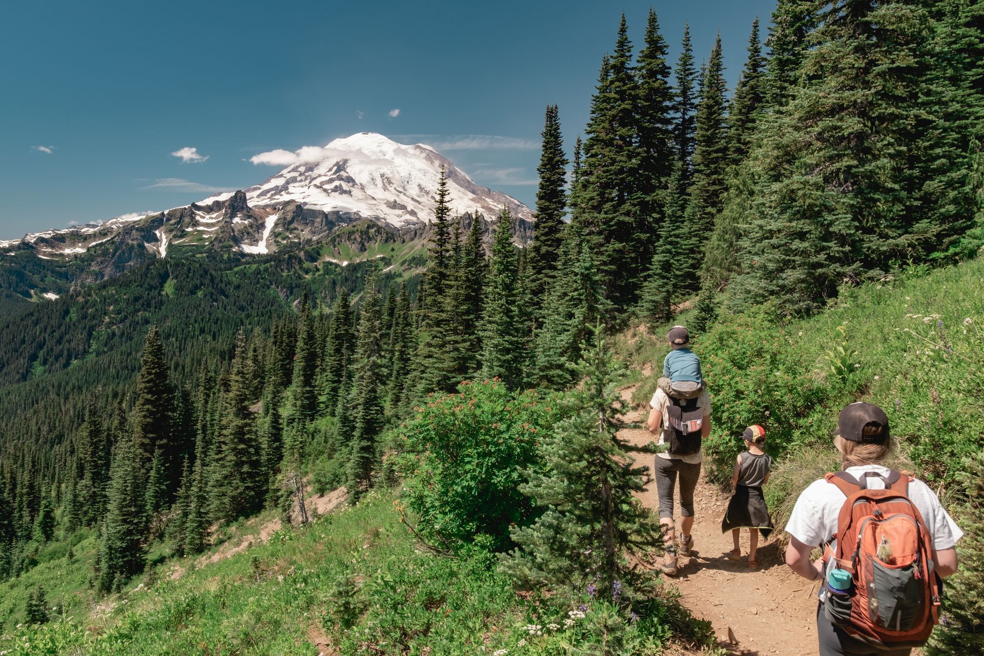 A group of people are hiking down a trail in the mountains.