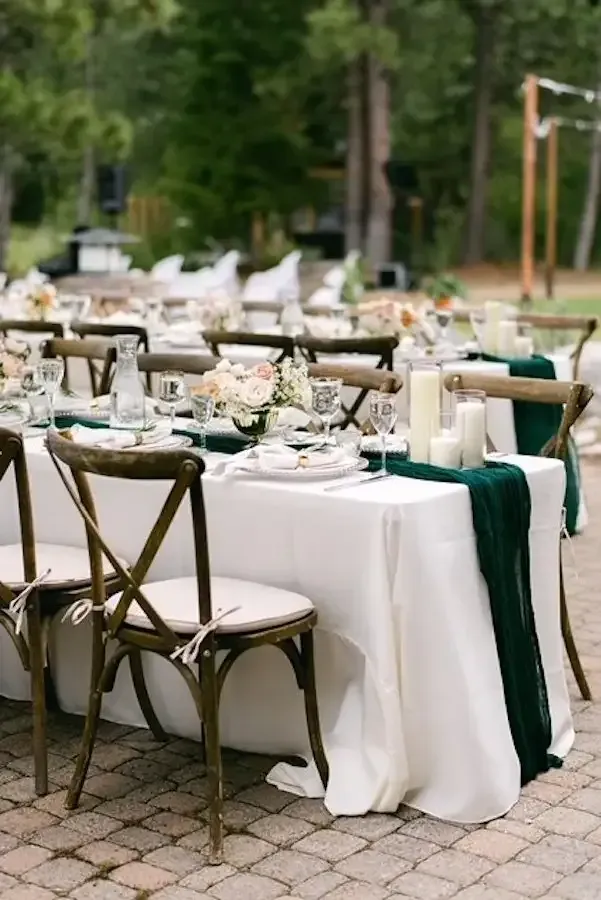 A table set up for a wedding reception on a brick patio.