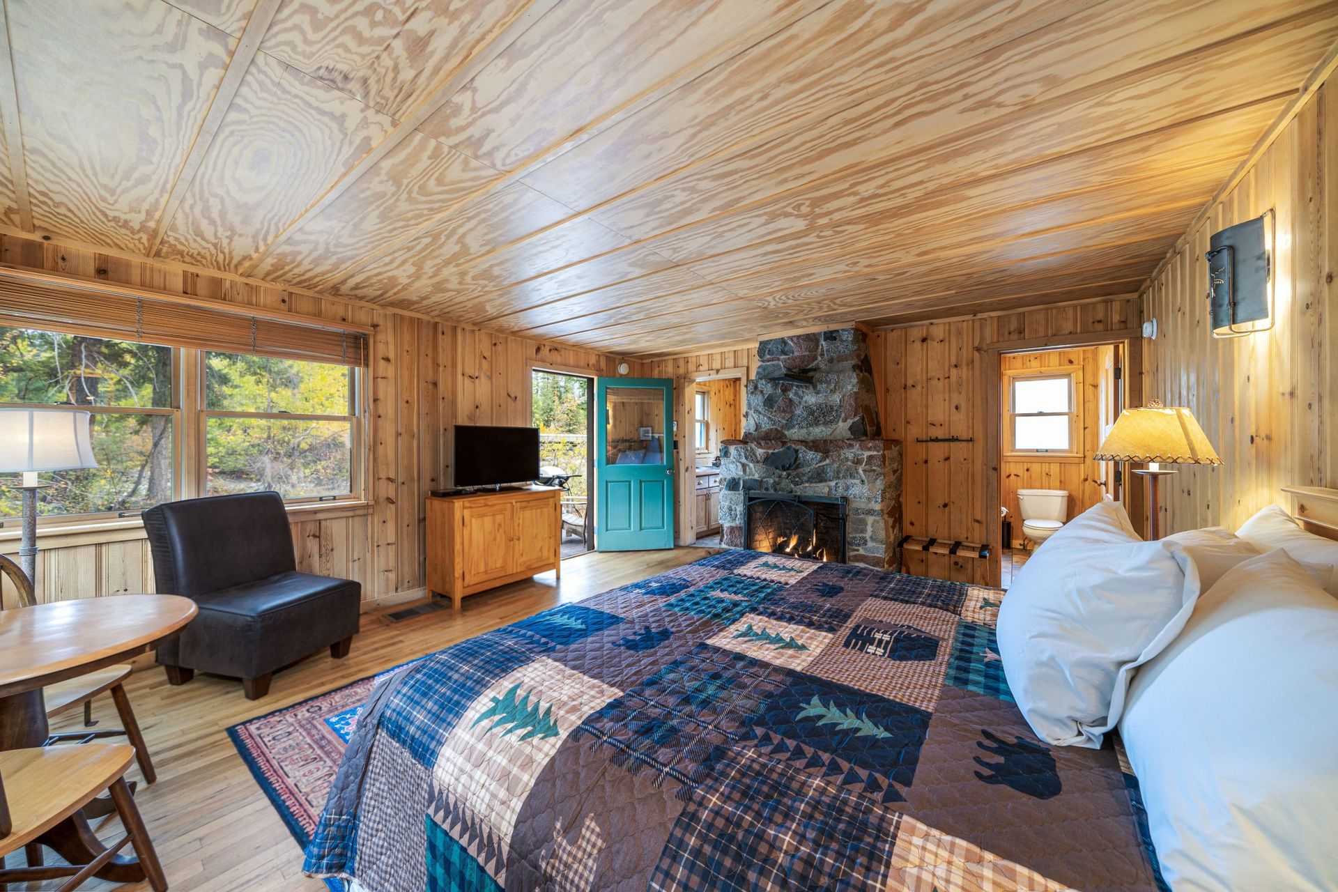A bedroom in a cabin with a king size bed and a fireplace.