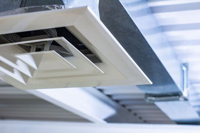 Un gros plan d'une bouche d'aération au plafond d'un bâtiment.
