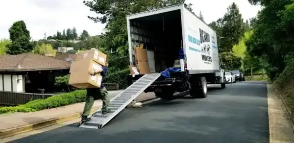 Moving truck unloading boxes down a ramp on a residential street