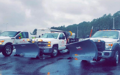 Snowplows blocking a wet road, forming a barrier on a rainy day.