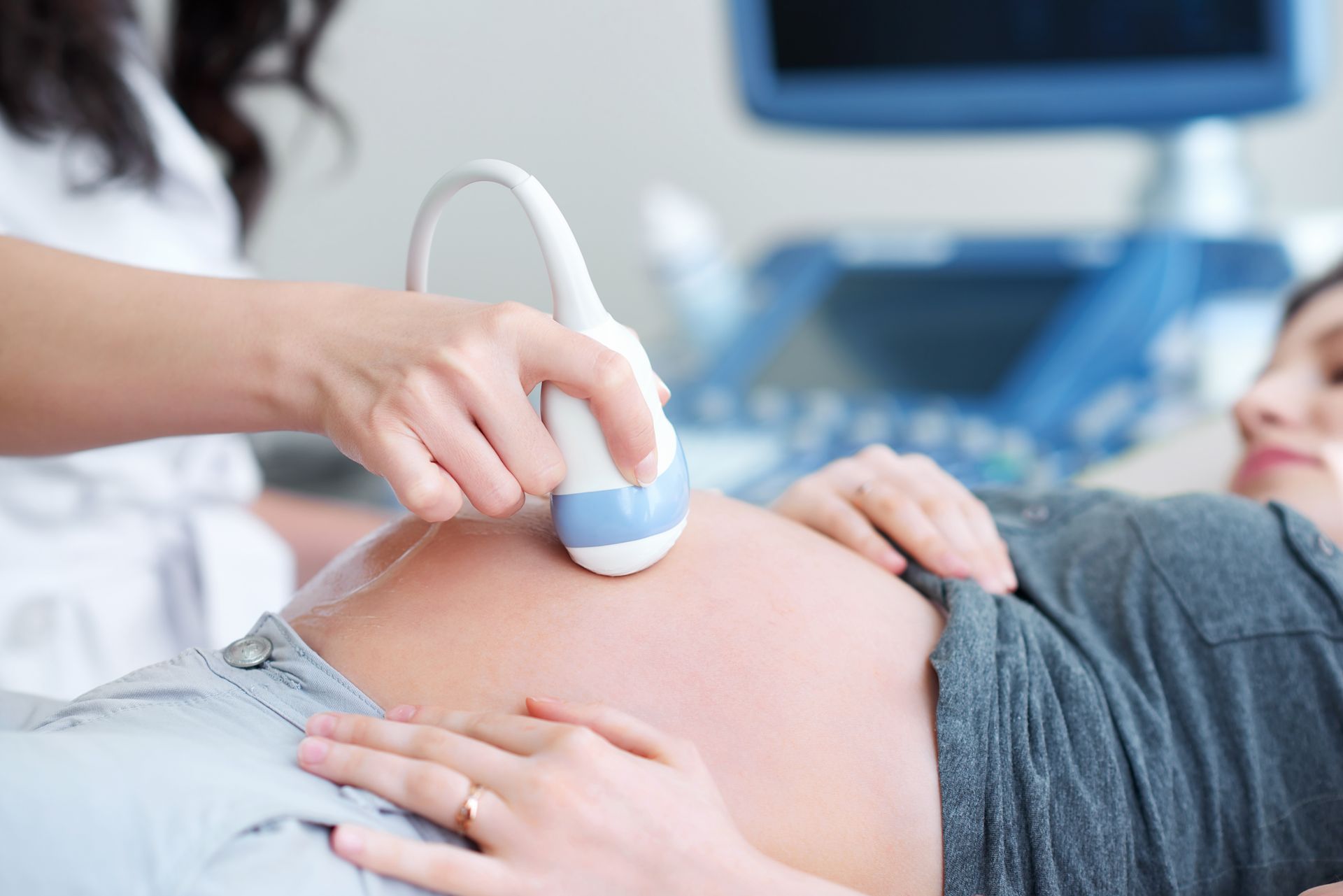 Obstetrics ultrasound examination on a pregnant patient's abdomen. Obstetrics ultrasound examination on a pregnant patient's abdomen.