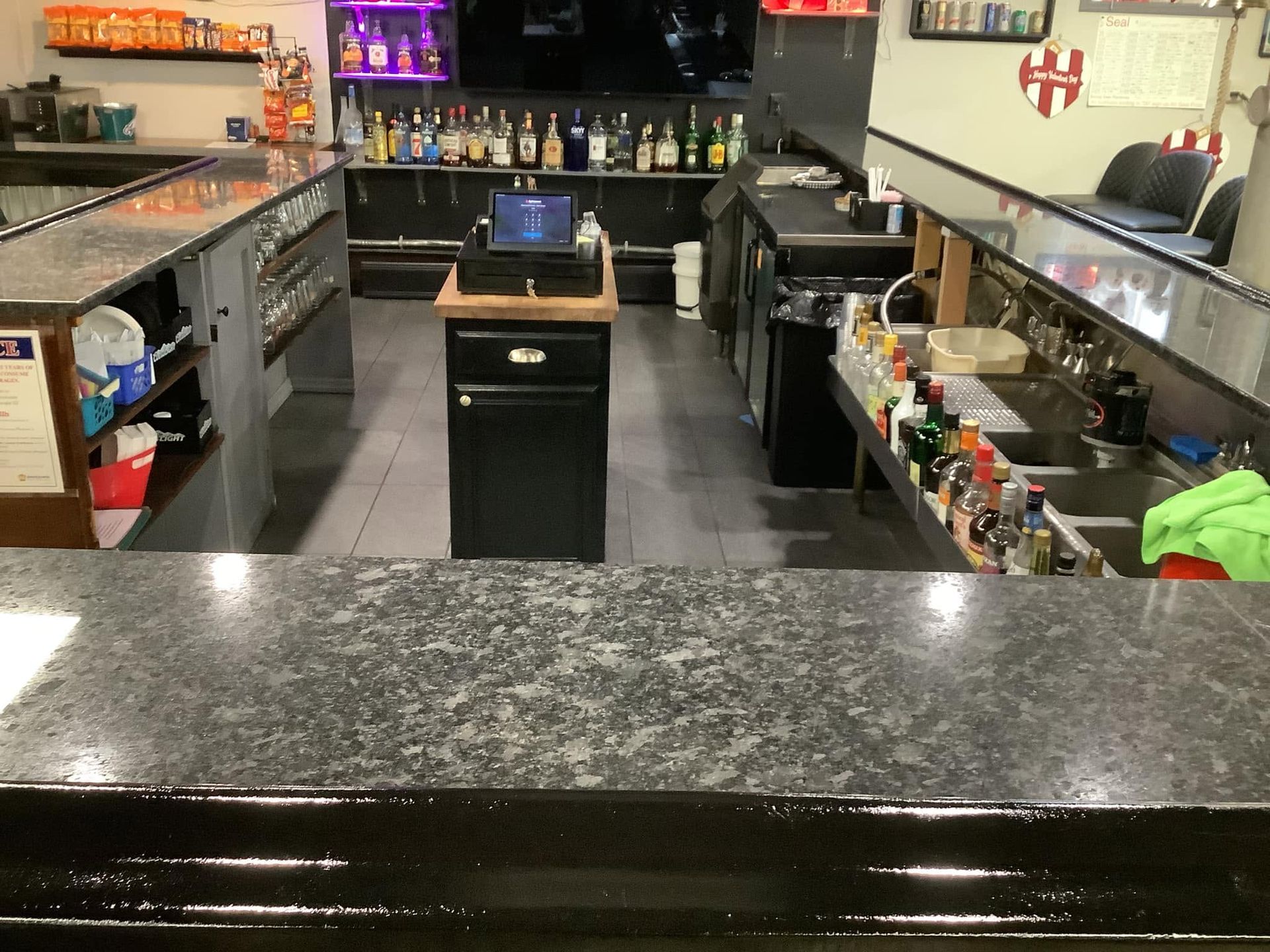 Commercial kitchen prep area with stainless counters, shelves, and a central island.