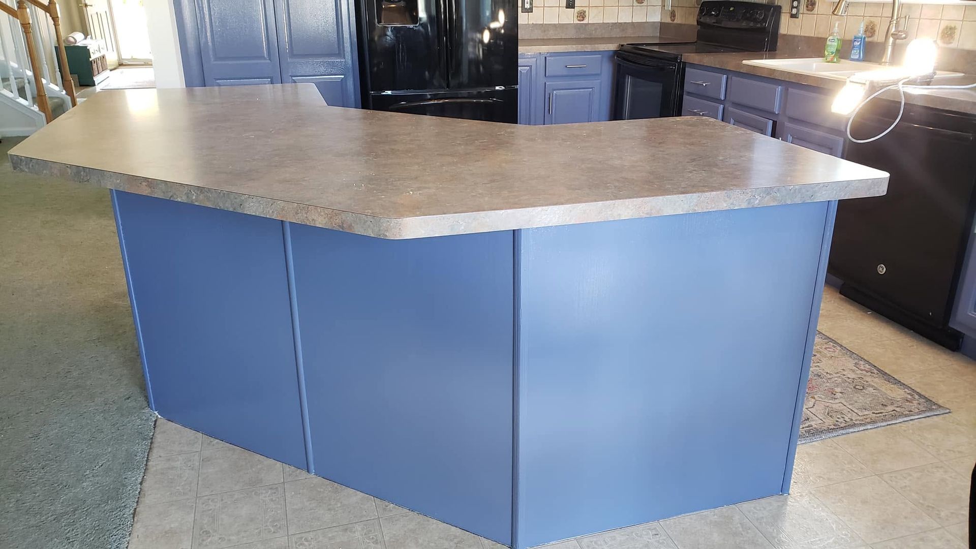 Blue kitchen island with beige countertop in a showroom or kitchen display