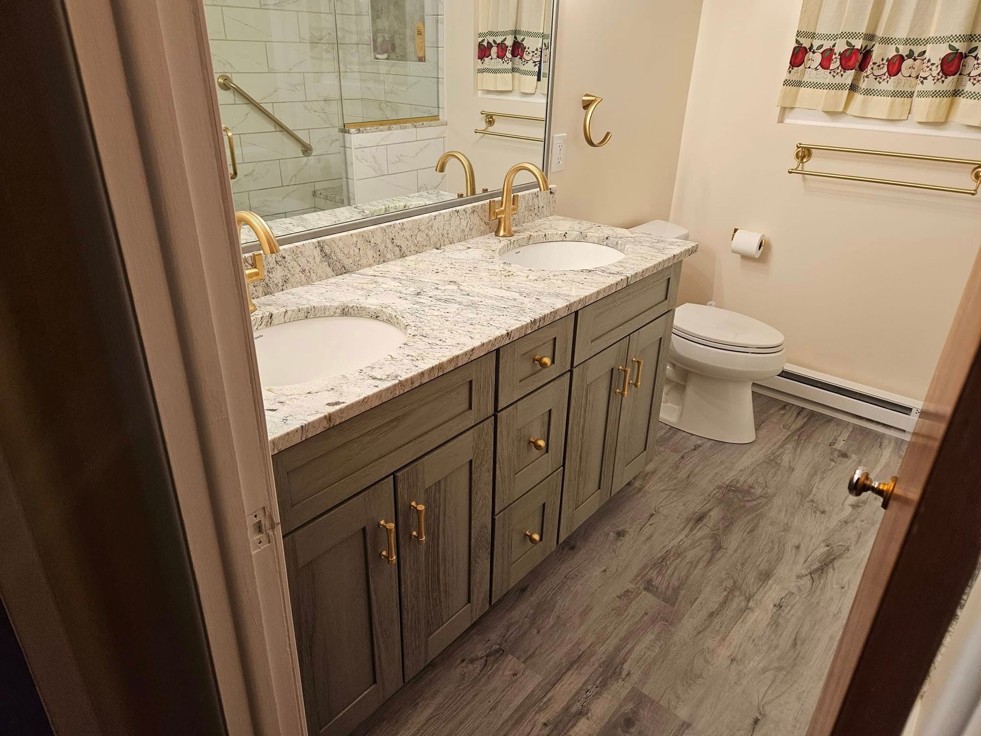 Bathroom with dark wood vanity, white countertop, wall mirror, toilet, and gray wood-look floor tiles.