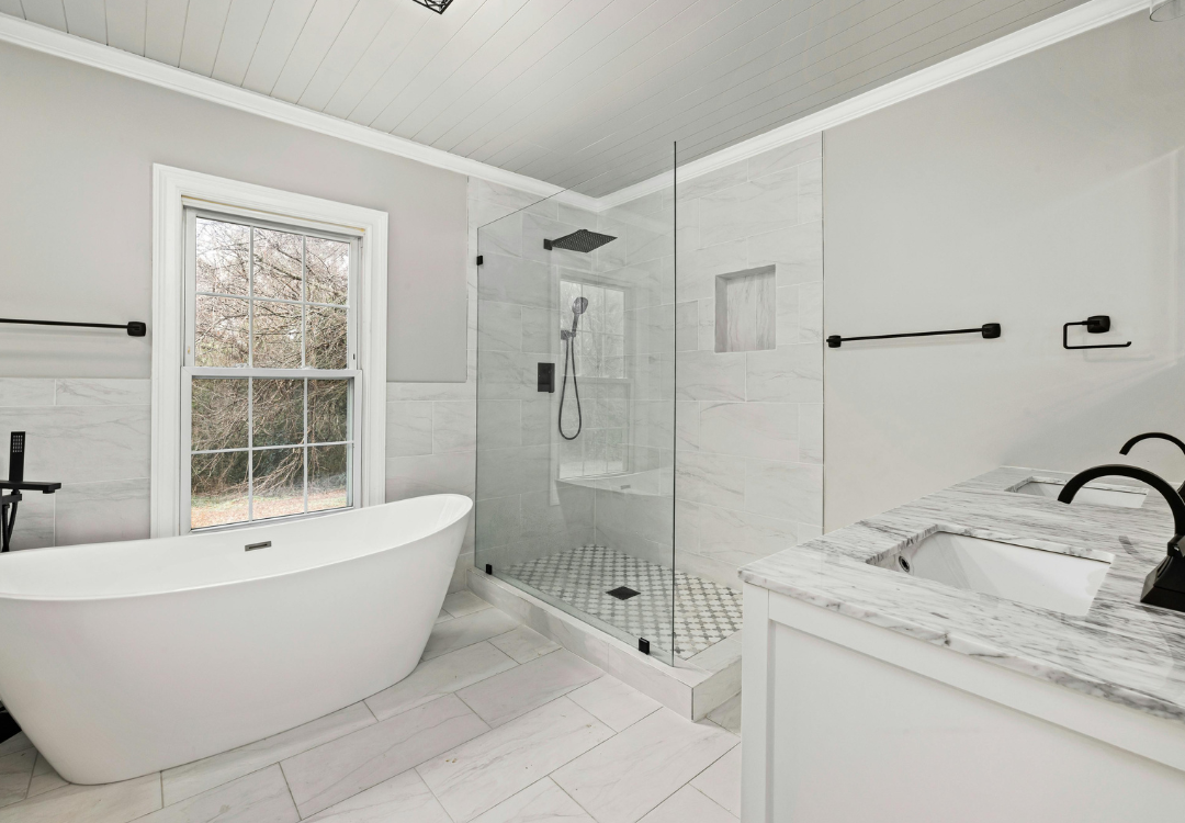 A bathroom with a bathtub , sink , and walk in shower.