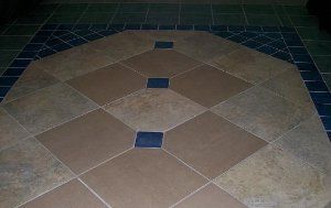A close up of a tiled floor with a blue border.
