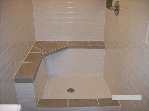 A bathroom with a walk in shower and a tiled bench.