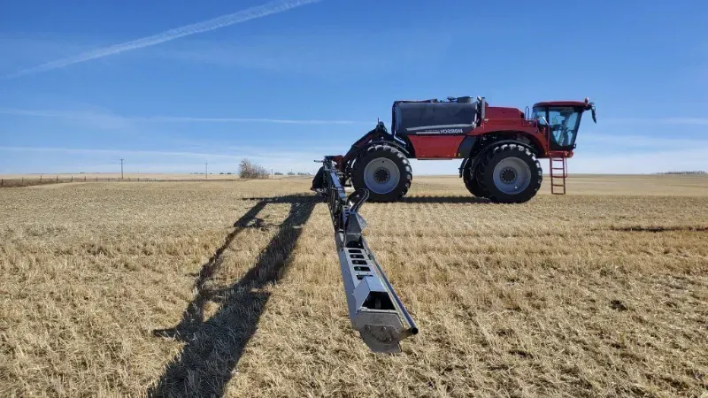 A red tractor is sitting in the middle of a field.