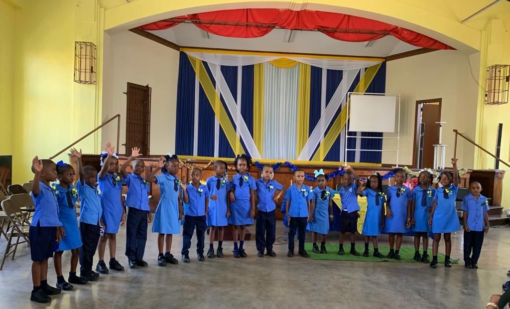 A group of children in blue uniforms holding certificates