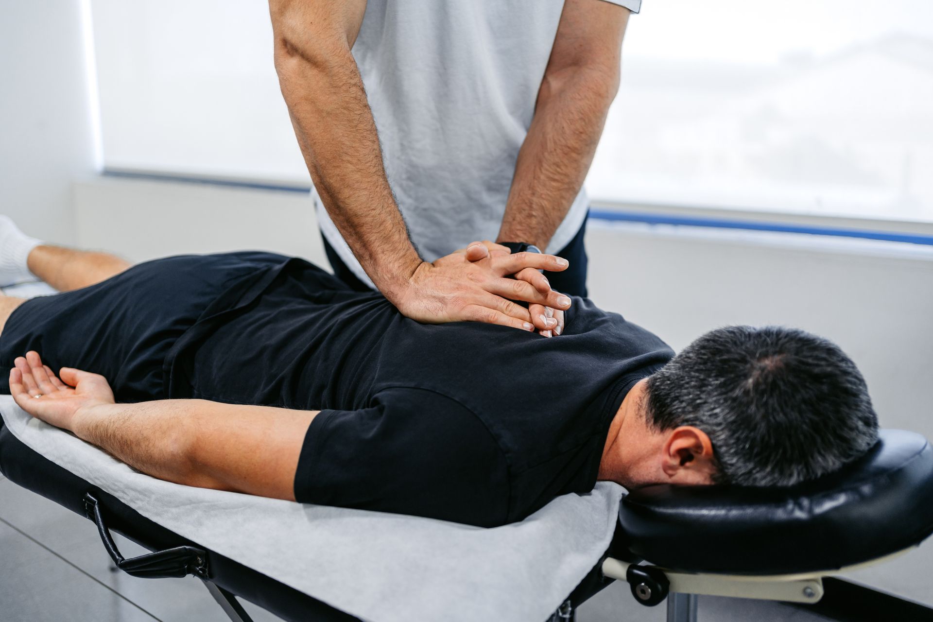 Un uomo è sdraiato su un lettino e riceve un massaggio da un medico.