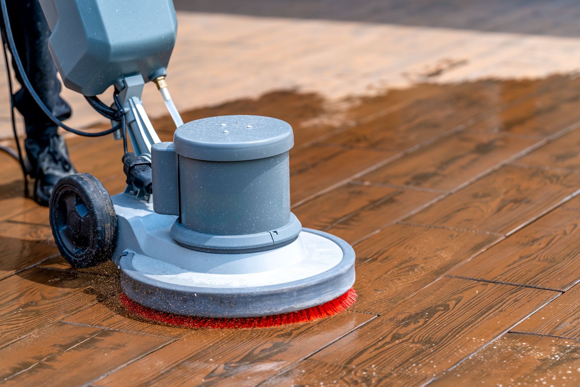 Floor cleaning machine scrubbing wooden planks. Floor cleaning machine scrubbing wooden planks.