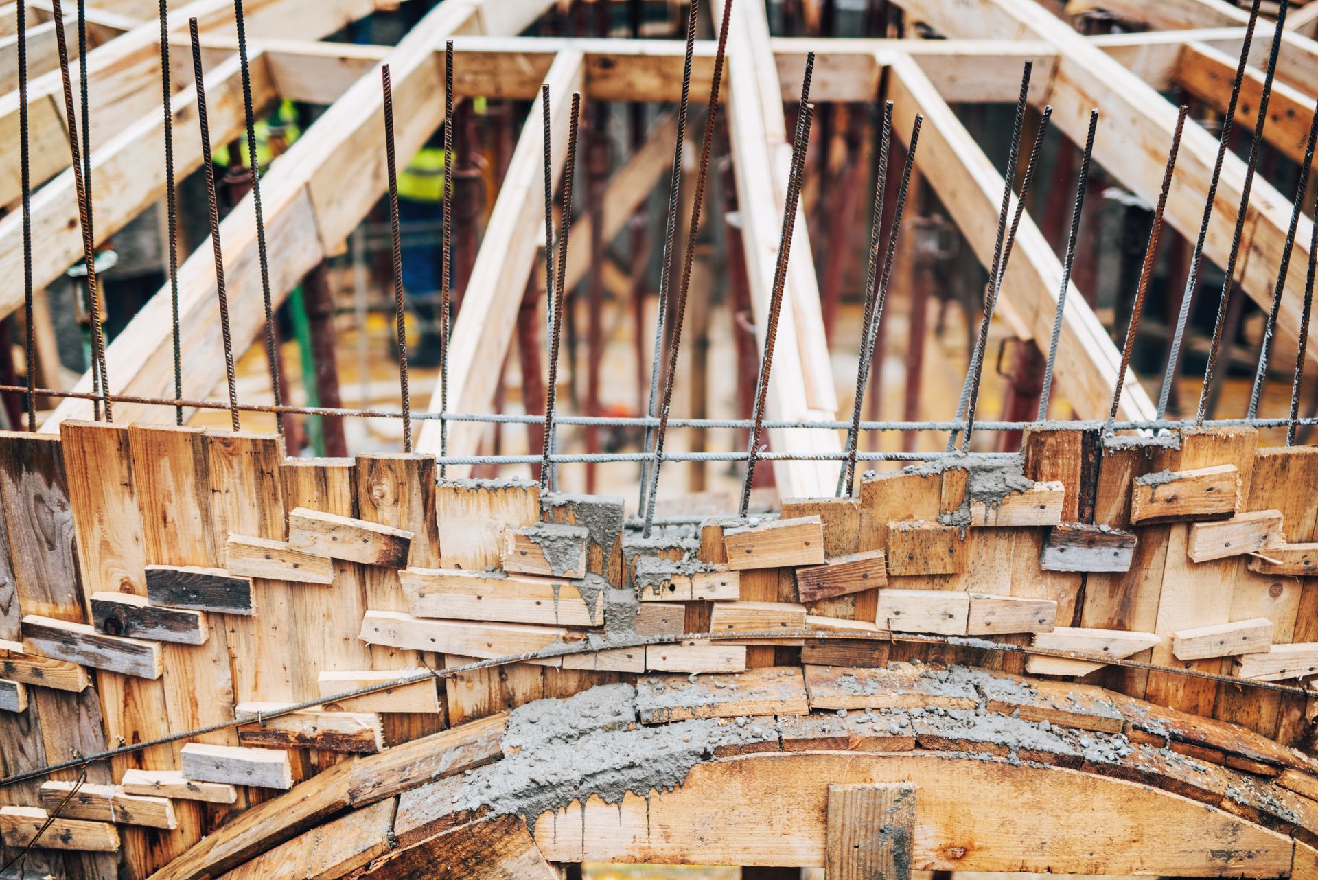 Construction of an arched structure, wooden framework, concrete blocks, steel rebar supports, and unfinished dome.