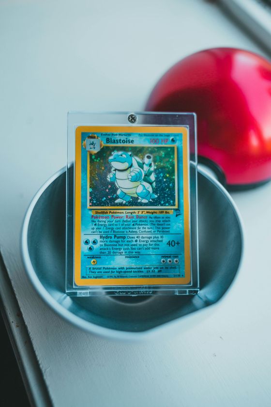 Pokémon card in a clear stand inside a round dish, with a red ball in the background