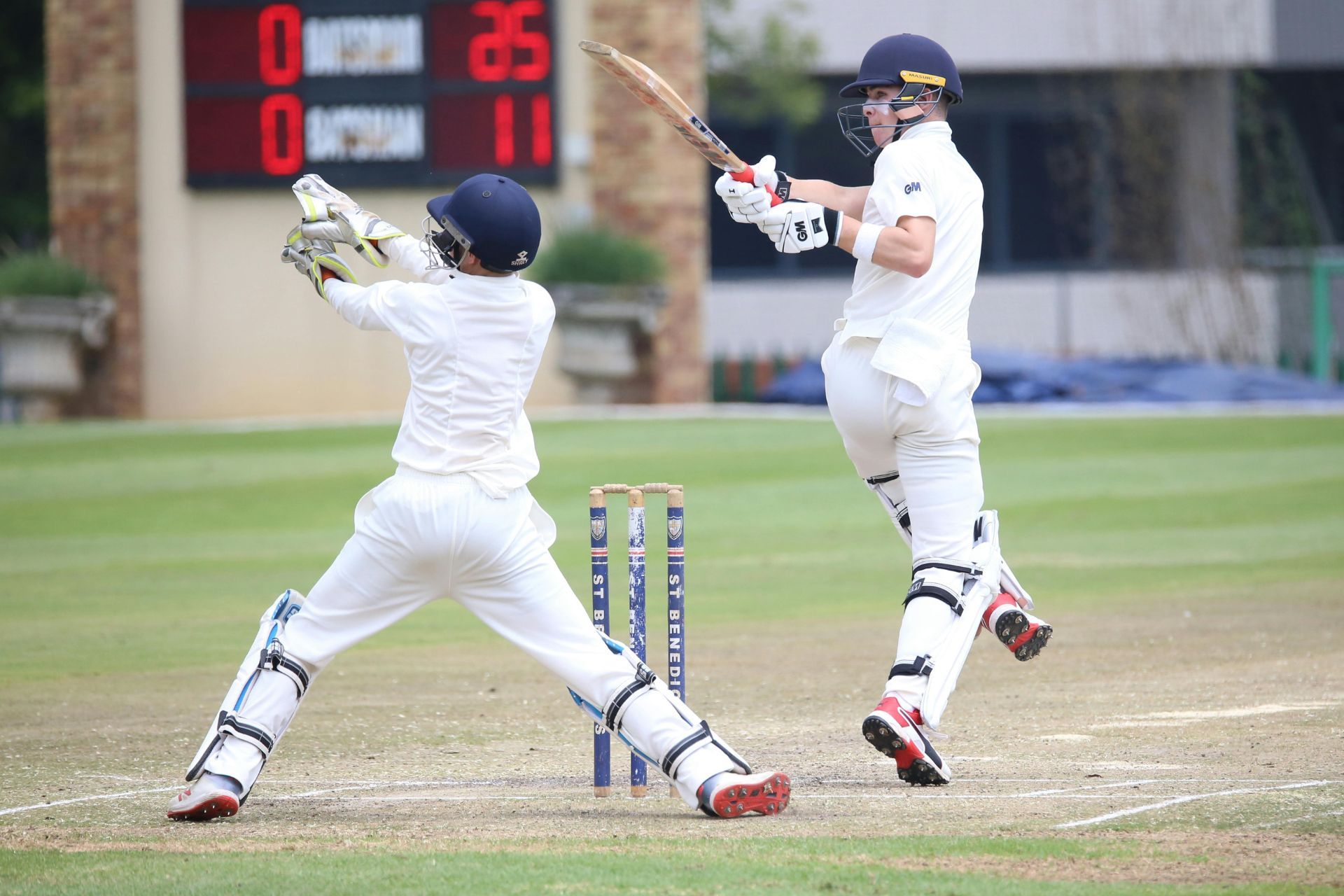 A batsman in cricket hits a shot into the gloves of the wicket keeper