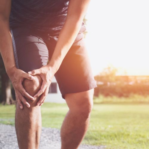 a man holding his knee in pain during a run