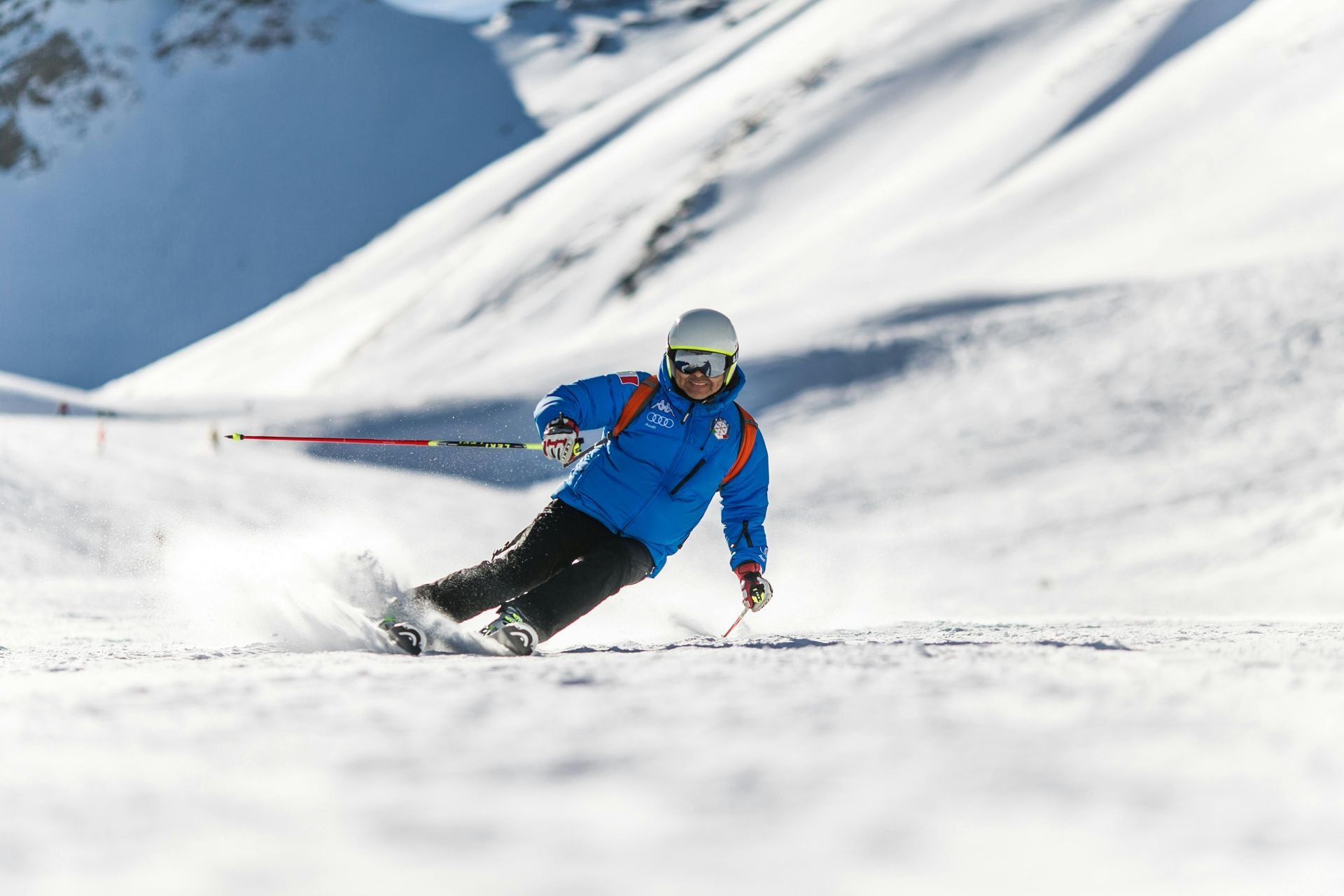 a skiier on descent down the slopes