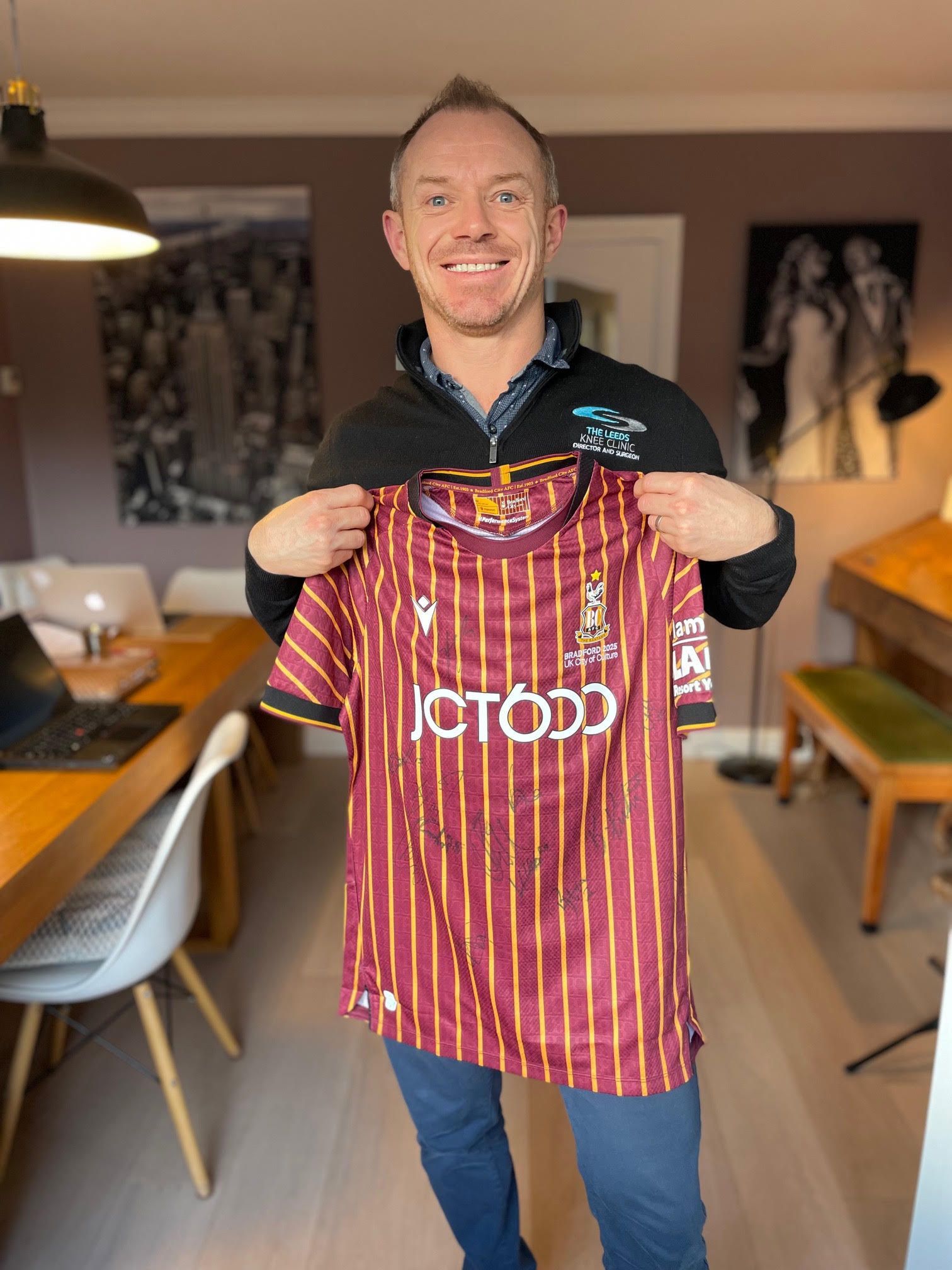 Mr Owen Wall holding a signed Bradford City shirt from Andy Cook